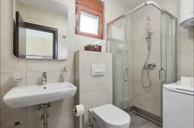 a bathroom with a sink toilet and a shower at Apartmani Nadja in Škaljari