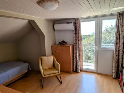 a bedroom with a bed and a chair and a window at Sunset Dreams Utjeha in Utjeha