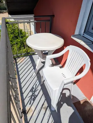 a white table and a white chair on a balcony at Sunset Dreams Utjeha in Utjeha
