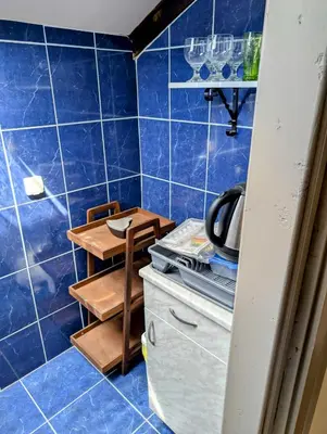 a blue tiled bathroom with a table and a stool at Sunset Dreams Utjeha in Utjeha
