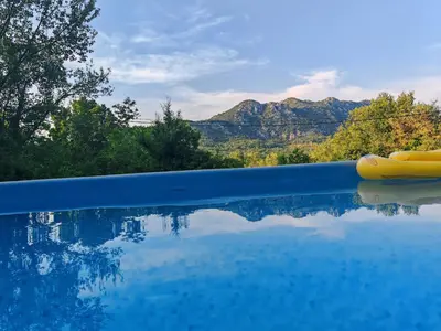 a swimming pool with a view of the mountains at Etno House Šćepanov Hlad in Virpazar