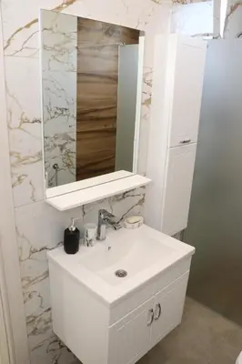 a bathroom with a white sink and a mirror at Panorama Hill Apartments Ulcinj in Ulcinj