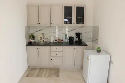 a kitchen with white cabinets and a white refrigerator at Panorama Hill Apartments Ulcinj in Ulcinj