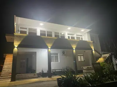 a large white house with lights in front of it at Panorama Hill Apartments Ulcinj in Ulcinj