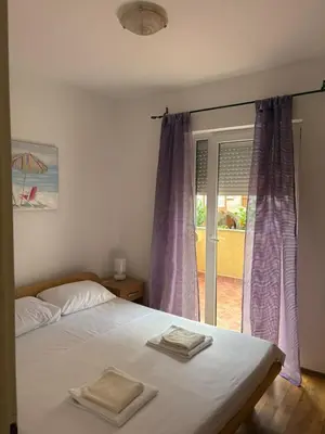 a bedroom with a bed with two towels on it at Two Bedroom Apartment Budva in Budva