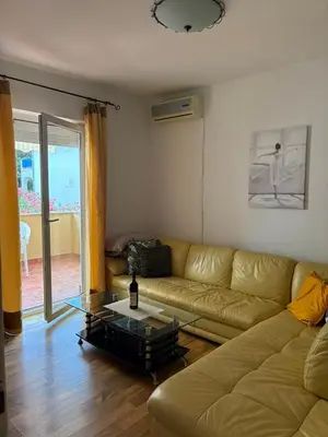 a living room with a couch and a glass table at Two Bedroom Apartment Budva in Budva