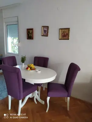 a white table and purple chairs in a room at Sea&Sun in Sutomore