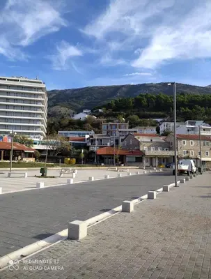 a street in a city with buildings and a mountain at Sea&Sun in Sutomore