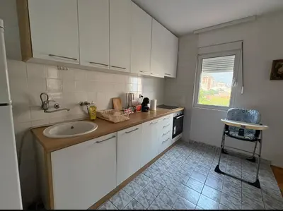 a kitchen with white cabinets and a sink and a window at Sea&Sun in Sutomore