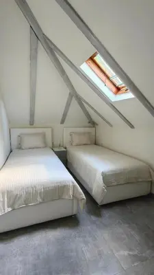 a attic bedroom with two beds and a window at Captain Double Suite in Kotor