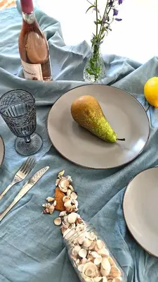 a table with plates of food and a pear and a knife at Captain Double Suite in Kotor