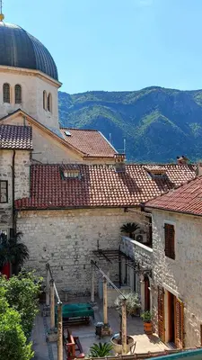 a group of buildings with a church and mountains in the background at Captain Double Suite in Kotor