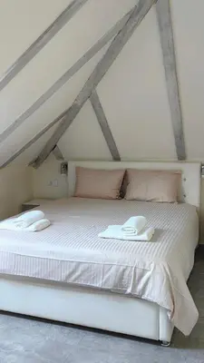 a bedroom with a large white bed with pink pillows at Captain Double Suite in Kotor