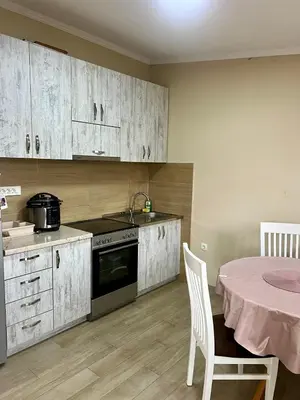 a kitchen with white cabinets and a table with a tablecloth at Casa di Lipa in Bar