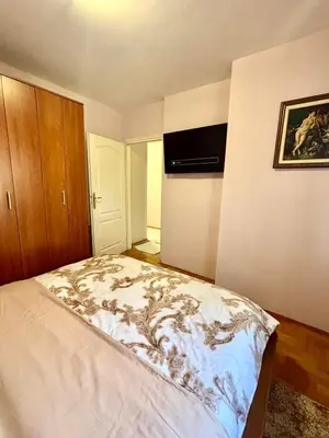 a bedroom with a bed and a television on the wall at Gold Lux in Podgorica