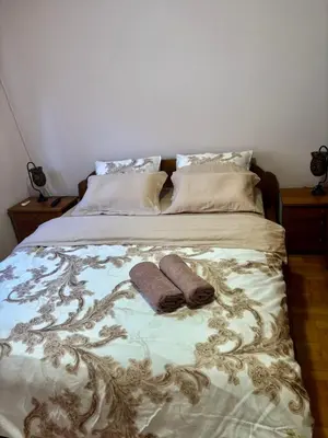 a bed with two mitts and two pillows on it at Gold Lux in Podgorica