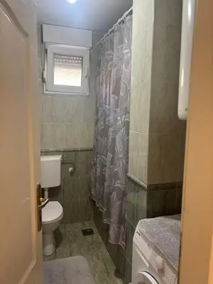 a bathroom with a toilet and a shower curtain at Gold Lux in Podgorica