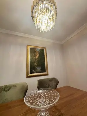a dining room with a table and a chandelier at Gold Lux in Podgorica