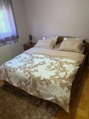 a bed in a bedroom with a blanket on it at Gold Lux in Podgorica