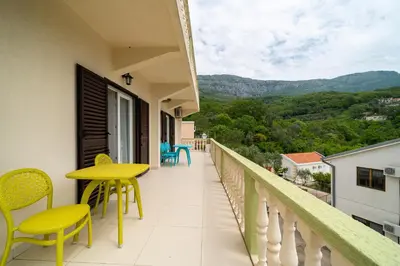 a balcony with yellow chairs and a yellow table and chairs at Guest House Ana in Petrovac na Moru