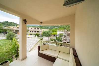 a balcony with a couch and a view of a street at Guest House Ana in Petrovac na Moru