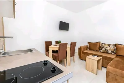 a kitchen and living room with a couch and a table at Guest House Ana in Petrovac na Moru