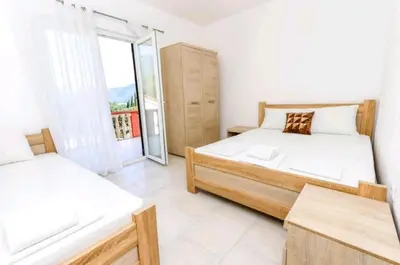 a bedroom with two beds and a large window at Guest House Ana in Petrovac na Moru