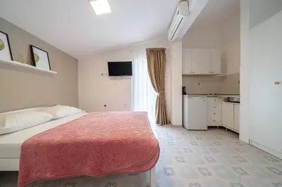 a small bedroom with a bed and a kitchen at Guest House Ana in Petrovac na Moru