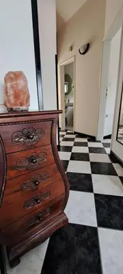 a wooden dresser sitting on a black and white checkered floor at Apartment Vujosevic D&D in Kotor