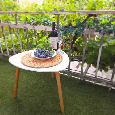 a table with a bottle of wine and a bowl of grapes at Apartment 086 in Cetinje