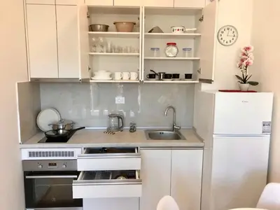 a small kitchen with a sink and a refrigerator at Apartments Oliva Mare Budva in Budva