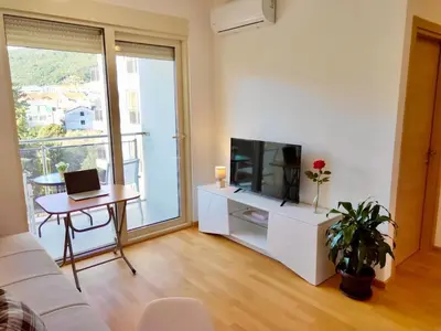 a living room with a couch and a tv and a table at Apartments Oliva Mare Budva in Budva