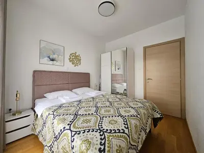 a bedroom with a bed with a quilt on it at Apartments Oliva Mare Budva in Budva
