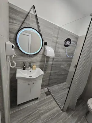 a bathroom with a sink and a shower and a mirror at Hostel Four Rooms in Ulcinj