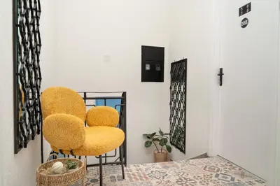 a room with two yellow chairs and a table at Hostel Four Rooms in Ulcinj