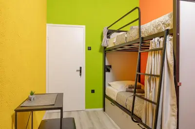 a room with two bunk beds and a table at Hostel Four Rooms in Ulcinj