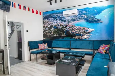 a living room with a blue couch and a painting on the wall at Hostel Four Rooms in Ulcinj