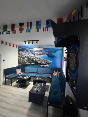a living room with a couch and a dart board at Hostel Four Rooms in Ulcinj