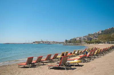 a row of lounge chairs on a beach at Apartment Lucky in Budva