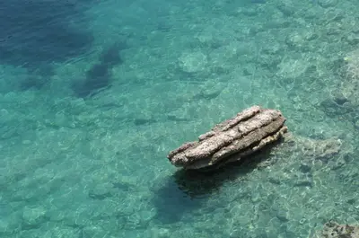 a rock in the water in the ocean at Apartment Lucky in Budva