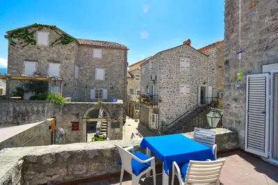 a blue table and chairs on a balcony with buildings at Apartment Lucky in Budva