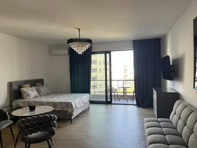 a bedroom with a bed and a couch and a table at Fusion Apartment in Dobra Voda