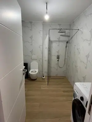 a bathroom with a toilet and a shower in it at Fusion Apartment in Dobra Voda