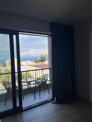 a balcony with a table and chairs and a view of the ocean at Fusion Apartment in Dobra Voda