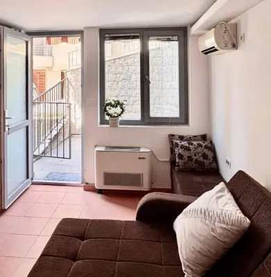 a living room with a couch and a window at Garsonjera in Kravlja