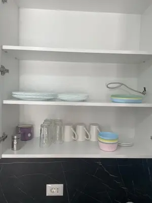 a kitchen shelf with plates and bowls on it at New apartment in Ulcinj in Ulcinj