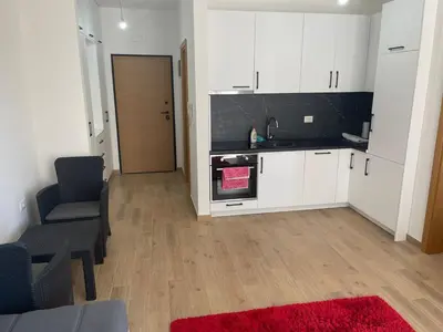 a kitchen with white cabinets and a red rug at New apartment in Ulcinj in Ulcinj