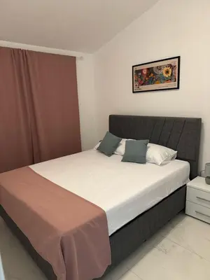 a bedroom with a large bed with white sheets and blue pillows at Midpoint See and Sun in Kotor