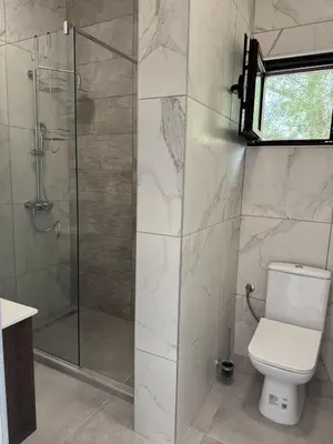 a bathroom with a toilet and a glass shower at Midpoint See and Sun in Kotor