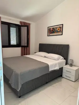 a bedroom with a large bed and a window at Midpoint See and Sun in Kotor